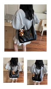 Détail d'un grand sac cabas noir en simili cuir avec un charmant ours en peluche marron