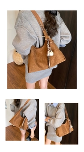 Detail of a brown suede Hobo tote bag with stylish coffee cup pendant and silk scarf