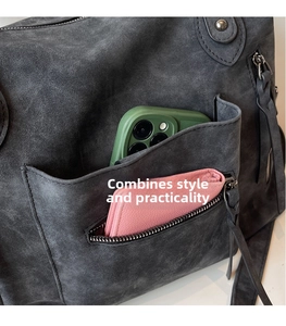 Dettaglio della borsa tote in pelle scamosciata grigia con multi-tasche e nappa decorativa