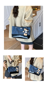 Detail of denim and leather patchwork tote with metal chain and bear charm pendant