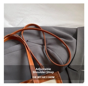 Détail de la bandoulière réglable en cuir et coutures sur le sac fourre-tout en toile