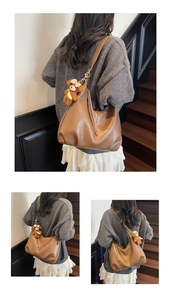 Détail d'un grand sac hobo marron en similicuir avec un joli petit pendentif en peluche