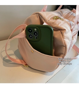 Detail view of the side pocket on pink fitness travel bag showing phone storage convenience