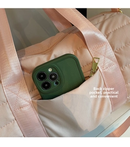 Close-up of the back zipper pocket on pink quilted travel bag with a smartphone inside