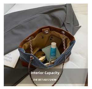 Detail showing high capacity tote with denim patchwork, silver chain, and magnetic closure