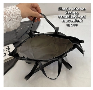 Top view of large black faux leather tote bag showing spacious interior and gray lining