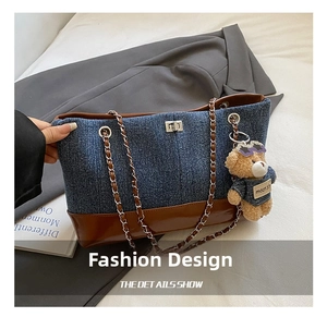 Detail showing the denim and leather patchwork with gold chain strap and teddy bear charm