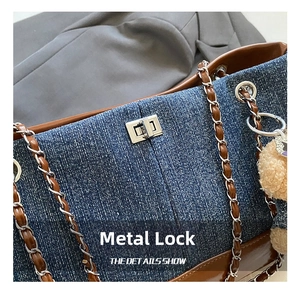Detail of silver twist lock and leather-chain strap on denim patchwork tote bag