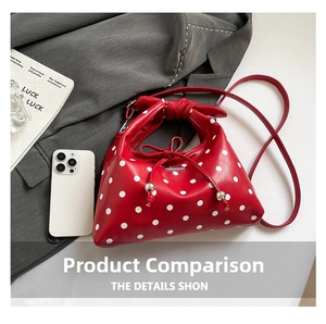 Detail view of red polka dot handbag with knotted handle and silver metal brand plaque
