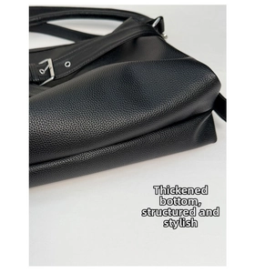 Detail shot of the thickened bottom and lychee pattern leather of the black tote bag