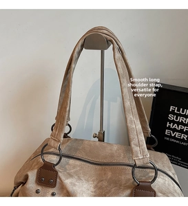 Detail of canvas tote bag with metal rivets and smooth long shoulder straps on a stand