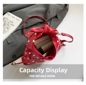 Detailed interior capacity view of red polka dot bag with large bow and silver hardware