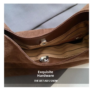 Détail du fermoir magnétique et de la poche zippée sur le sac cabas en daim marron
