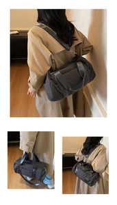 Detail of dark grey quilted nylon barrel bag with detachable strap and top handle
