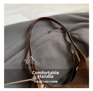 Détail des poignées réglables en cuir et texture daim marron sur un grand sac cabas