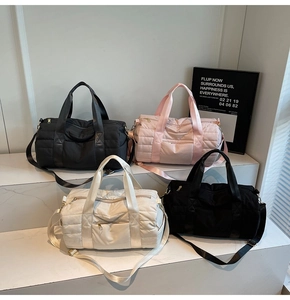Close-up of quilted nylon travel bags in multiple colors with webbing handles and straps