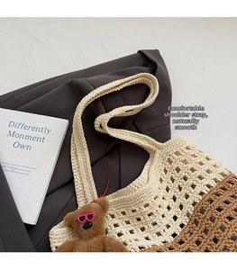 Close-up of two-tone woven tote bag with hollow knit pattern and a cute bear charm