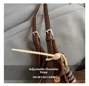 Détail de la bandoulière en daim réglable avec boucle argentée et cordon tressé