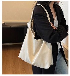 Detail of soft cream tote bag with large capacity and stylish knotted shoulder strap detail