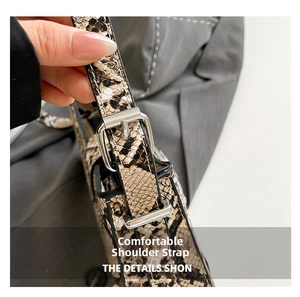 Detailed view of adjustable snakeskin pattern shoulder strap with silver metal buckle