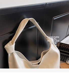 Detailed view of knots on beige hobo shoulder bag hanging in an urban office setting