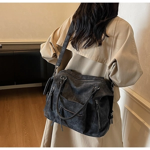 Detailed view of charcoal gray vintage matte tote bag worn by a model in a beige trench coat