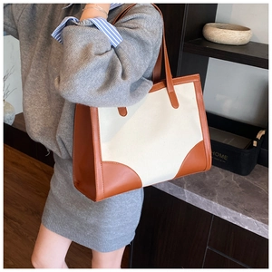 Modèle portant un grand sac cabas en toile et cuir marron pour le style quotidien