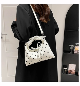 Polka dot handbag with bow handle and drawstring detail shown from a back carry perspective