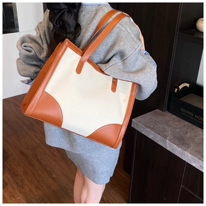 Photo lifestyle d'un grand sac cabas en toile avec détails en cuir marron sur un mannequin