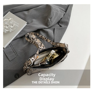 Interior view of snakeskin crossbody bag showing phone, lipstick and makeup storage