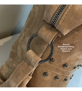 Macro shot of brown textured tote bag with dark grey metal rivets and reinforced rings