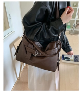 Detail of dark brown lychee pattern leather tote with adjustable metal buckle strap