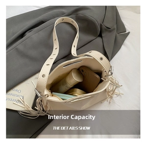 Top view of cream crossbody bag showing interior storage capacity and tassel detail
