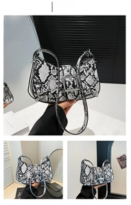 Detailed view of black and white snake skin shoulder bag with silver buckle