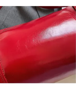 Detailed macro view of vibrant red high-gloss leather texture with smooth finish