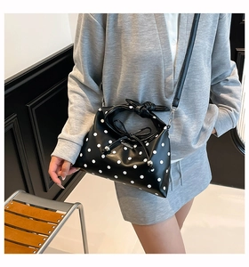 Polka dot hobo bag with knotted handle shown on model in a modern interior