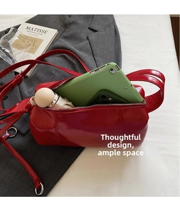 Detail view of a spacious red barrel bag containing a tablet, phone, and umbrella