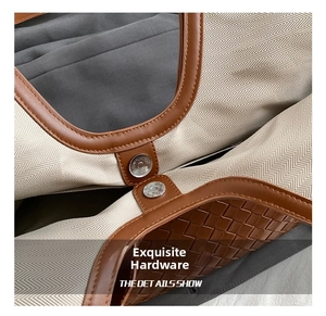 Detail of magnetic buckle closure on canvas and woven leather tote bag with gray lining