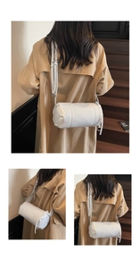 Detailansicht einer weißen Leder-Zylindertasche mit verstellbarem Gurt am Modell