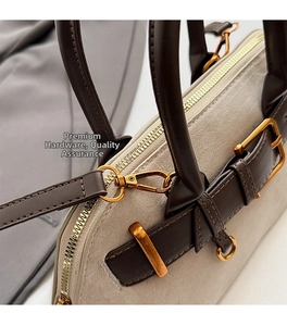 Close-up of beige suede seashell bag with premium gold hardware and brown leather handles