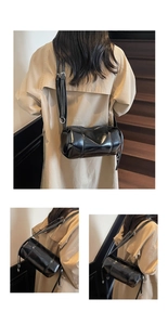 Detailaufnahme der schwarzen glänzenden Zylindertasche mit verstellbarem Lederriemen