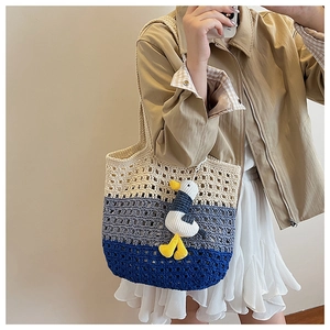 Detailed knit of a three-tone gradient crochet tote bag with a cute character pendant