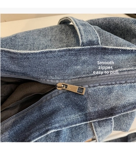 Close-up of durable smooth metal zipper and black fabric lining on denim tote bag