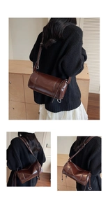 Detail einer dunkelbraunen Vintage Zylindertasche mit Metallringen und Ziernähten