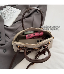Close-up of beige suede bag interior showing spacious storage for wallet and phone