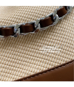 Detail showing woven beige fabric texture with brown leather trim and silver chain