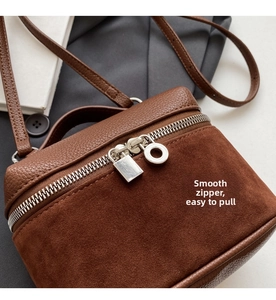 Close-up of vintage brown leather crossbody bag with silver lock zipper details
