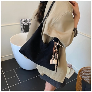 Détail du grand sac cabas en daim noir avec breloque tasse à café et accessoire