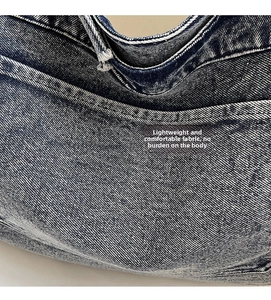 Detailed close-up of retro washed blue denim fabric texture and fine stitching on tote bag