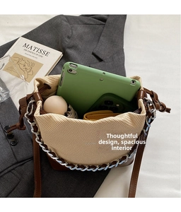 Overhead view showing spacious bucket bag interior with a tablet, umbrella, and wallet